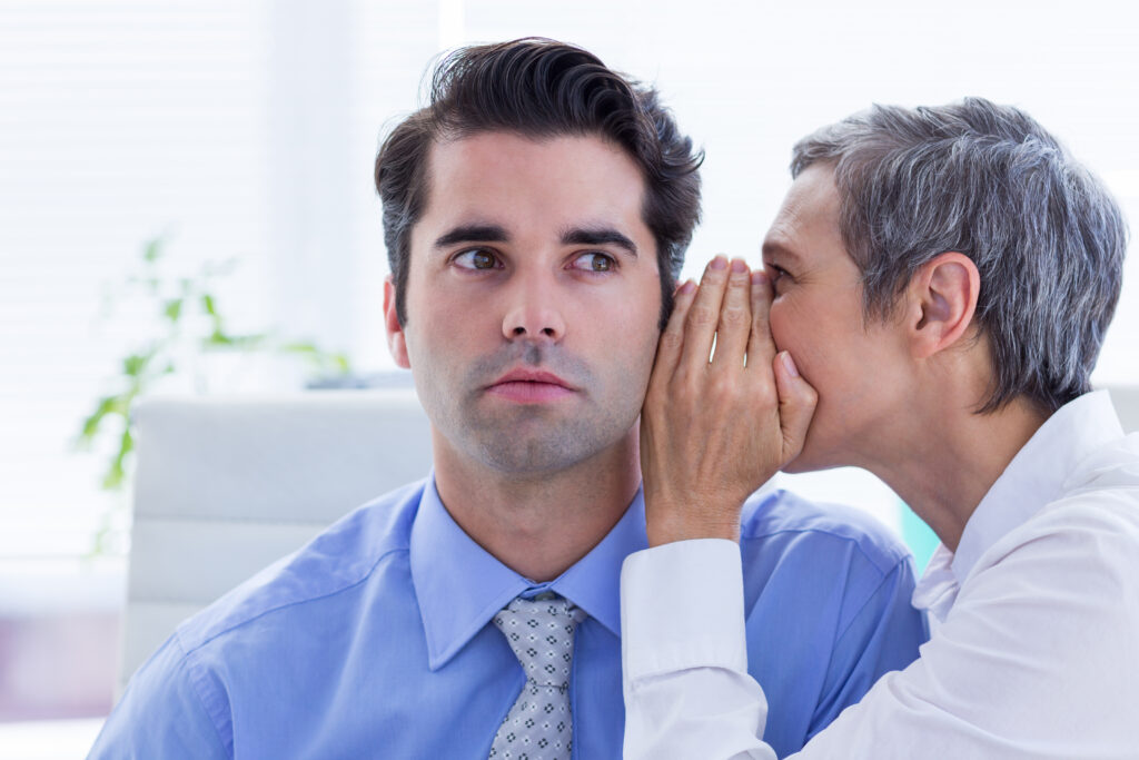 A woman whispering to a colleague with no sales experience
